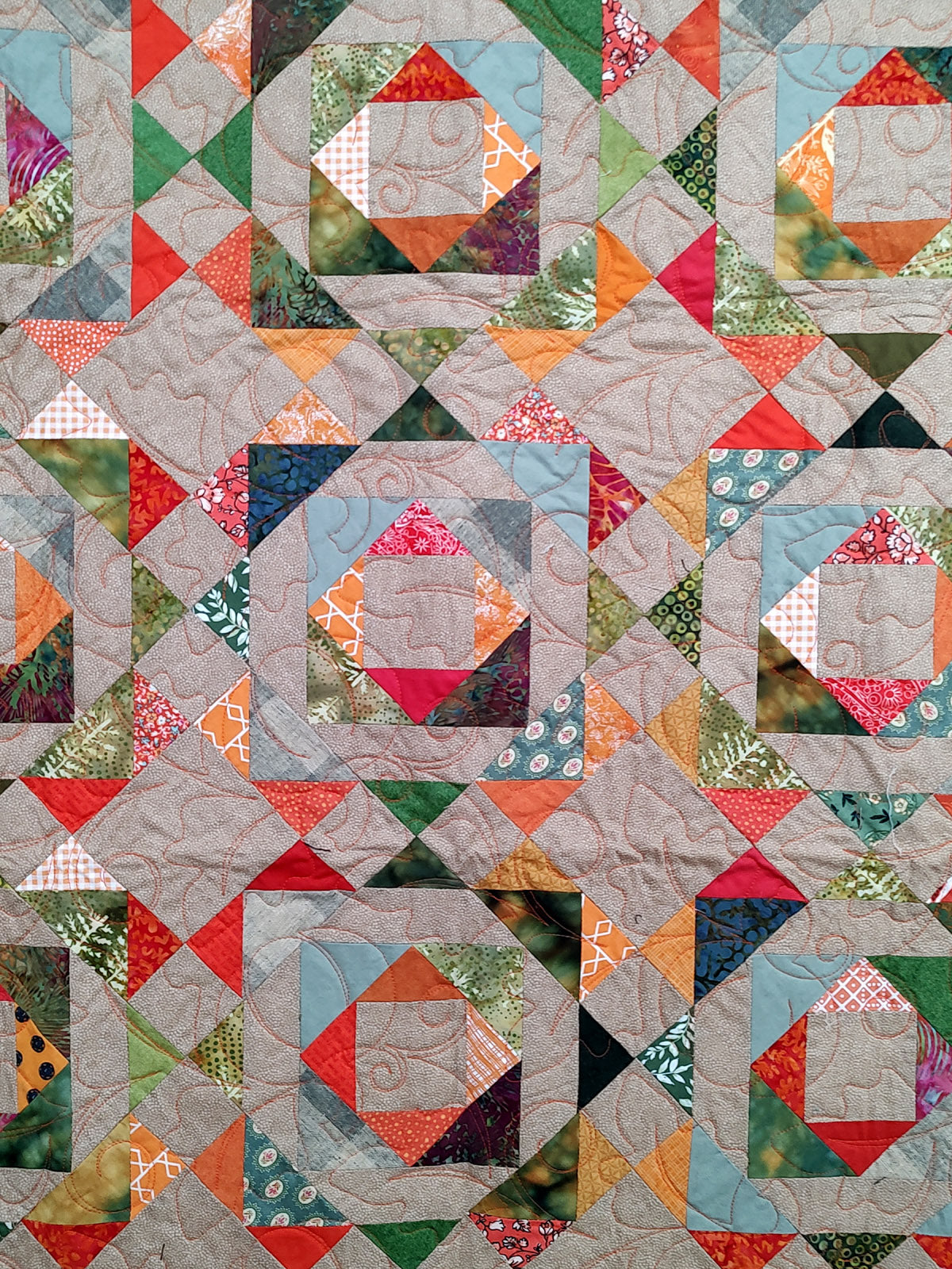 Fall colored scrappy green, brown, orange baby lap quilt