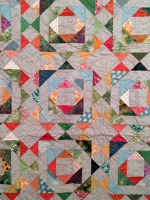 Fall colored scrappy green, brown, orange baby lap quilt